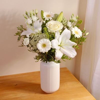 Celebrate any occasion with our elegant yet understated bouquet featuring pristine white Lilies and Roses, meticulously arranged to convey timeless grace and beauty. Hand created by our skilled local florists, you can buy this exquisite arrangement online and have the flowers delivered to your doorstep or directly to your loved ones. Perfect for Easter March 31st 2024 or any special moment, this stunning bouquet is sure to evoke joy and appreciation